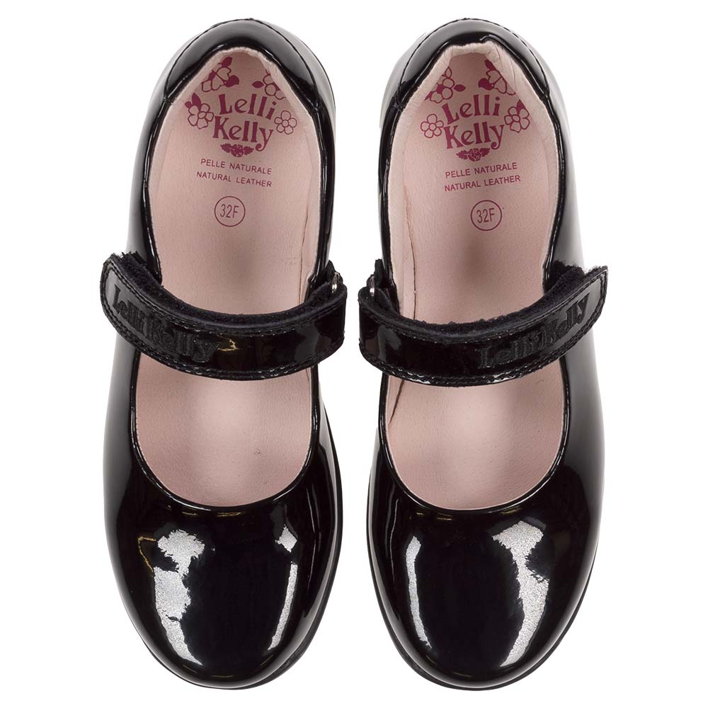 Maribella 2 school shoe This shoe features a single self-closing strap adorned with a colorful enamel Mermaid charm, with a black patent finish and an F fitting. The leather lining and cushioned insole provide added comfort, while the lightweight, flexible, non-slip rubber sole and padded ankle support make for a practical and stylish school shoe. Complete with a pair of black grosgrain bows that can be worn on the strap